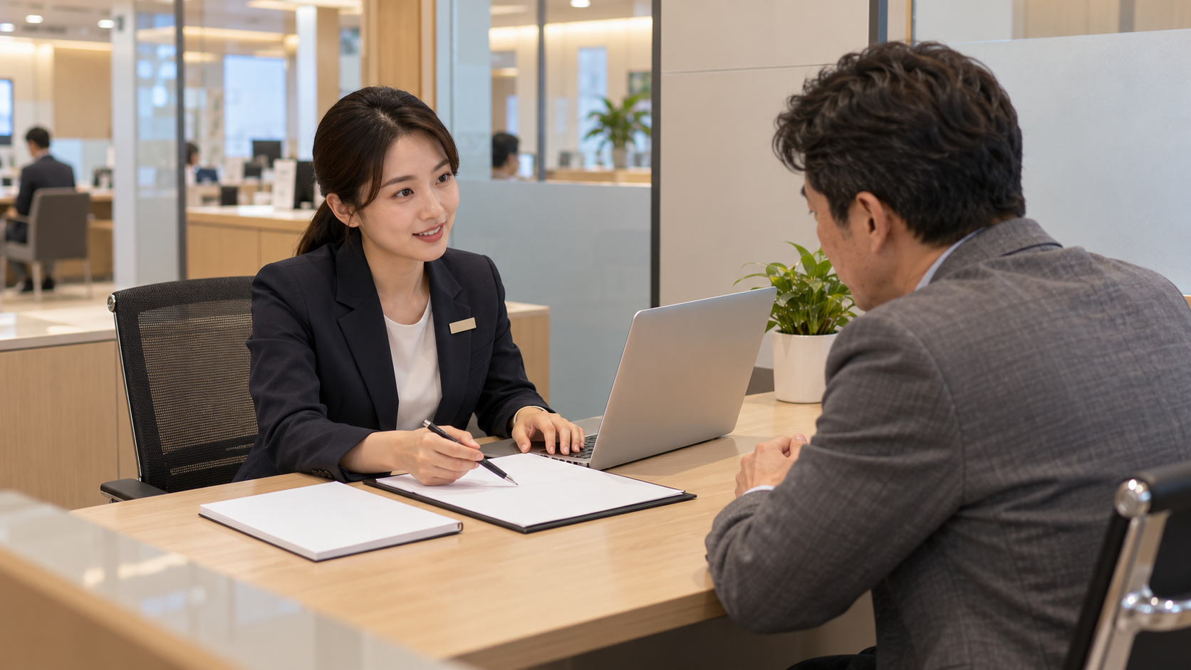 亞洲中年男性在銀行諮詢小間向女性行員了解債務整合方案